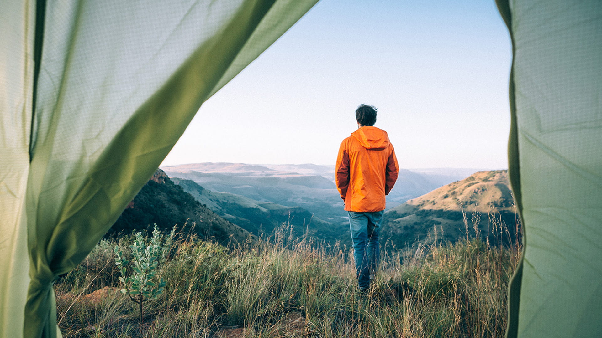 Man standing by his campsite looking at the mountains