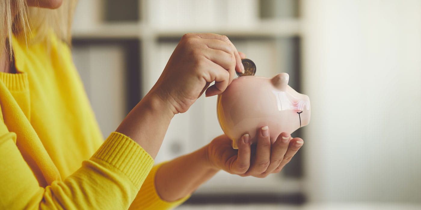 Woman adding to piggy bank