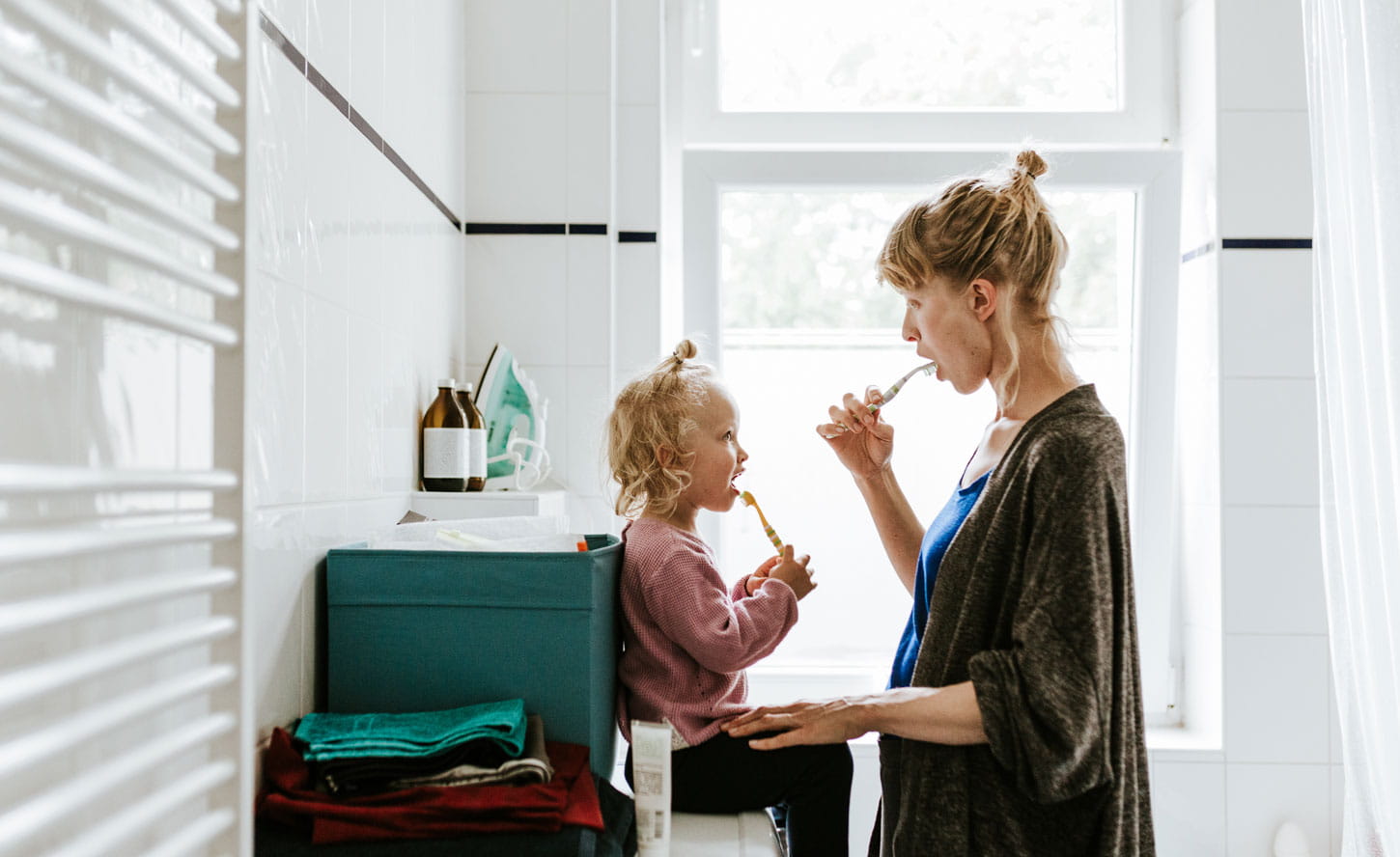 Mother and daughter brushing their teeth