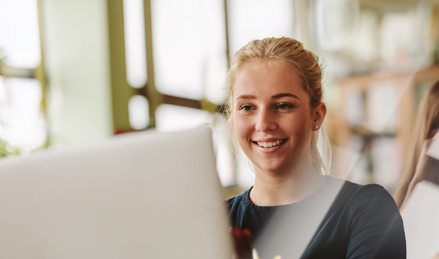 Woman smiling at computer screen